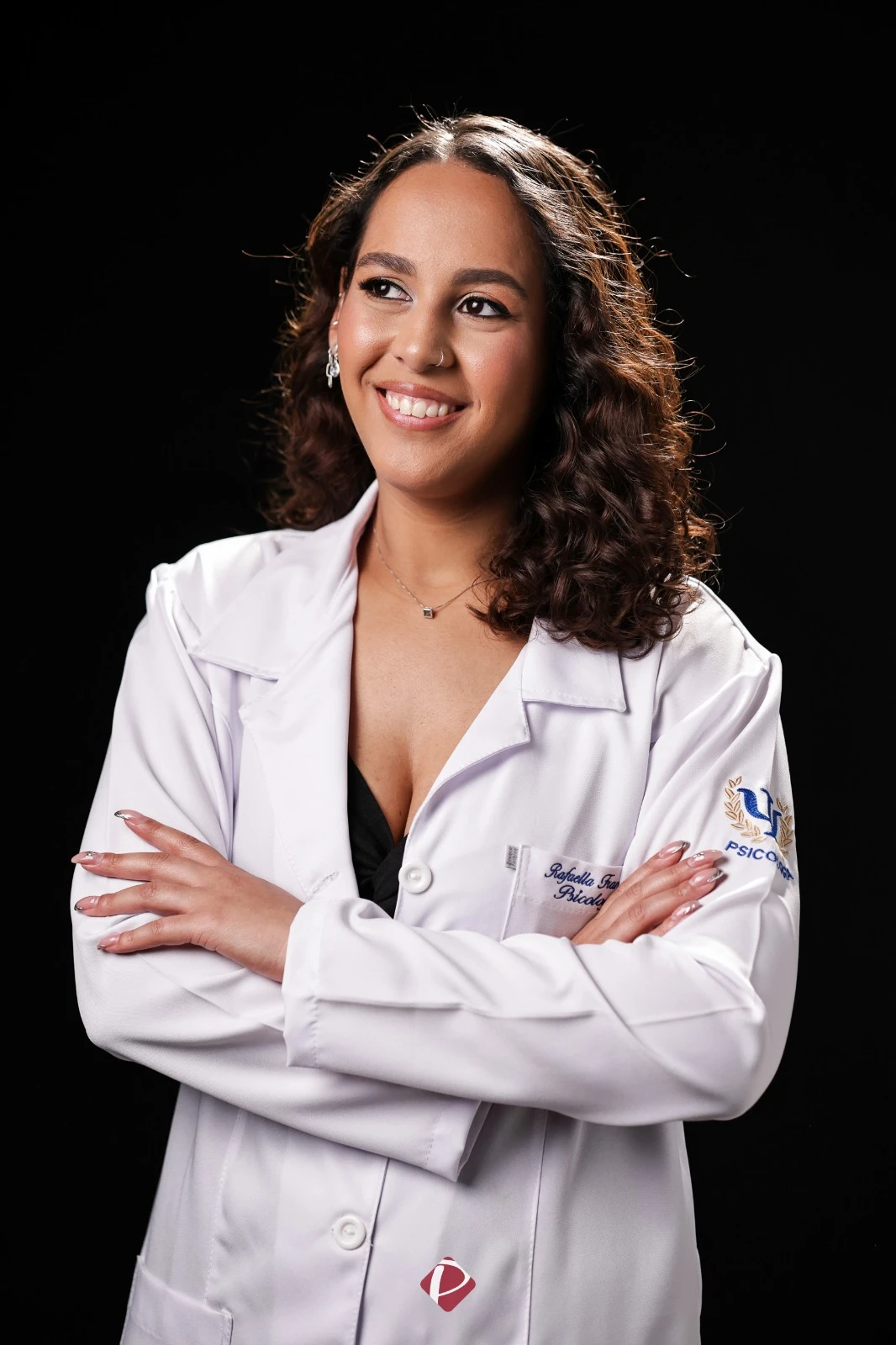 Rafaella Francisca sorrindo, de jaleco branco e braços cruzados